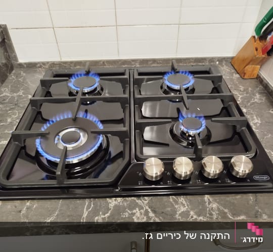 כיריים גז עם ארבעה מבערים דולקים